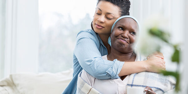 Mid adult woman embraces her senior mom adult child embracing her ill senior mother