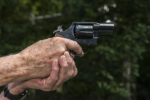 senior aiming a revolver pistol