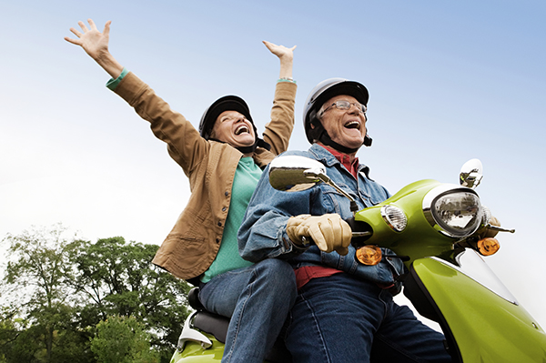 happy-senior-couple-on-moped Senior couple having fun riding motor scooter.