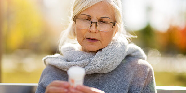 Senior woman checking label on medication Senior woman checking label on medication