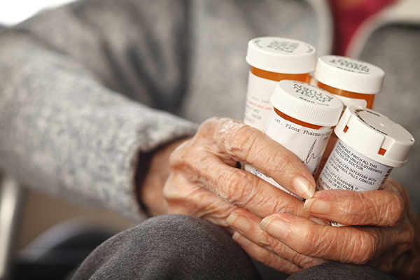 Prescription Medicine Senior citizen female holding bottles of prescription medicine sitting in a wheelchair.