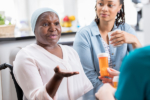 Senior female patient discusses concerns about her medication with an unrecognizable home healthcare nurse.