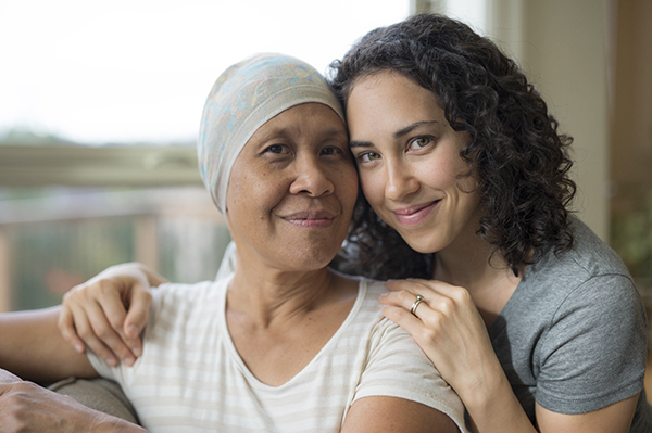 Ethnic young adult female hugging her mother who has cancer young adult female hugging her mother who has cancer