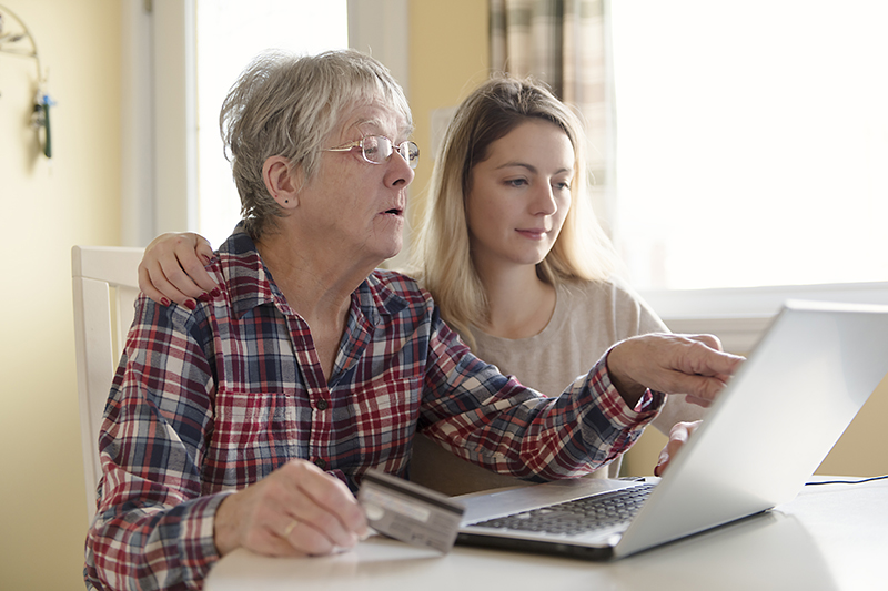 Senior woman with her daughter online purchasing together