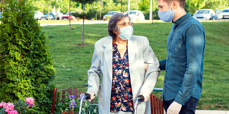 senior woman outside with male caregiver senior woman outside with male caregiver