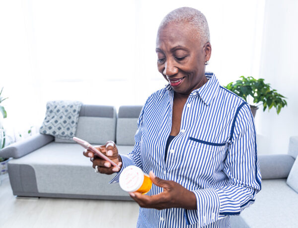 Woman Checking Information on Her Medicine Senior woman holding pills and reading the information on the label