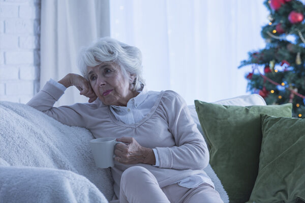 sad senior woman sitting on couch sad senior woman sitting on couch