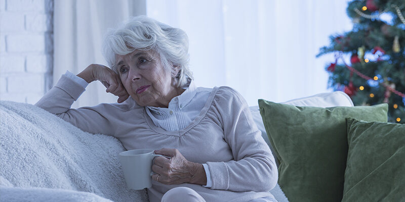 sad senior woman sitting on couch sad senior woman sitting on couch