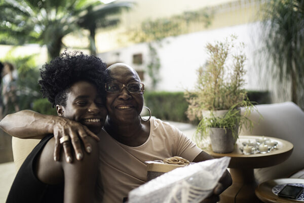 Granddaughter giving a surprise gift to grandmother Granddaughter giving a surprise gift to grandmother