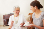 elderly lady having tea with her daughter