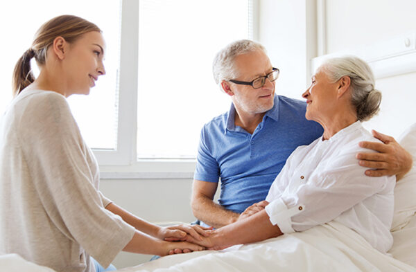 caregiver comforting senior couple