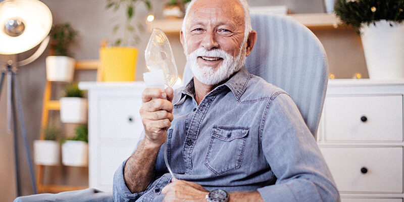 happy-senior-man-holding-oxygen-mask-with-copd