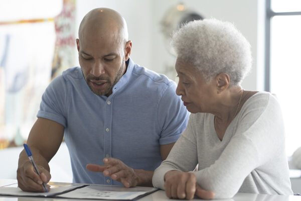 Portrait of a beautiful woman Family caregiver helping elderly loved one with paperwork