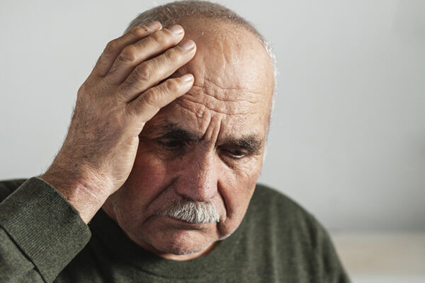 Portrait of a beautiful woman Elder man holding his head in discomfort