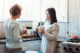 Two women stand in the kitchen sharing a cup of coffee and having difficult care conversations.