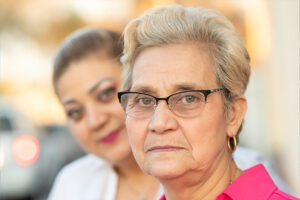 A senior stares into the camera after being asked, “What do family caregivers need?”